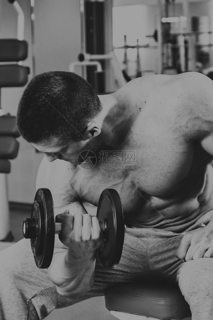健美运动员在健身房用哑铃锻炼手上的工作告诉肌肉精疲力尽的锻炼到此结束体育杂志图片