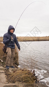 河岸的渔民一个年轻的渔夫钓图片