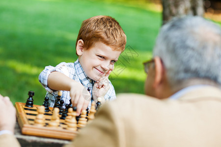 祖父和孙子在公园下棋图片