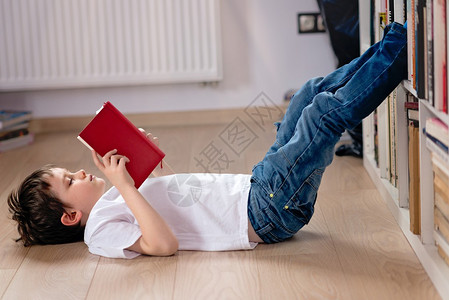 小男孩在图书馆看书他躺在地板上图片