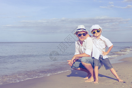 父亲和儿子白天在沙滩上玩耍友善家庭的概念图片