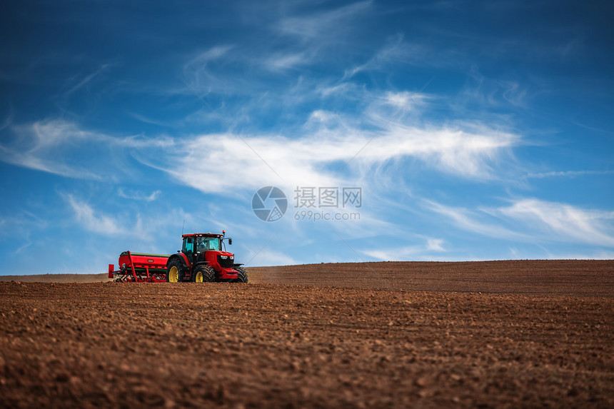 拖拉机播种作物田的农夫图片