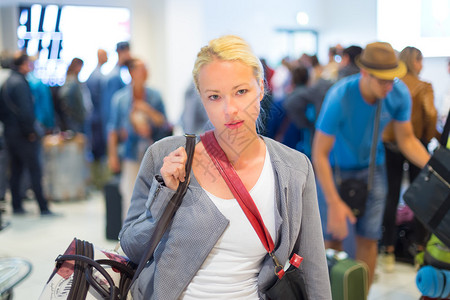 穿着随意的年轻时尚女旅客在机场到达候机厅等候图片