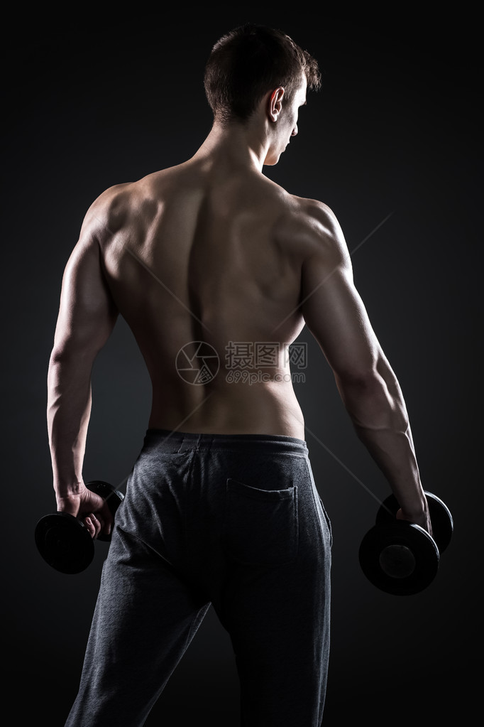 肌肉健壮的人用黑色背景后视手握哑铃图片