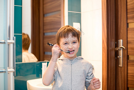 7岁小男孩在浴室刷牙穿着灰色图片