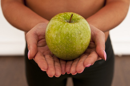 成熟的青苹果在手背景图片