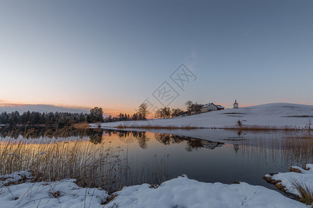 冬天在湖边的山上种田在日落背景图片