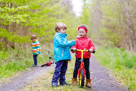 女孩和男孩在雨天骑着自行车图片