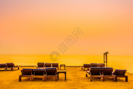沙滩上空椅子与日落时间旧式过滤器和背景图片