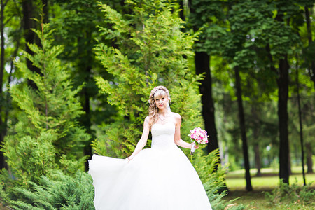 美丽的新娘在绿公园露户外的鲜花图片