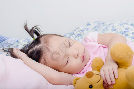 睡觉在床上的小亚裔女孩图片