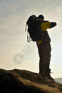 带着运动背包和手杖的游客站在悬崖上图片