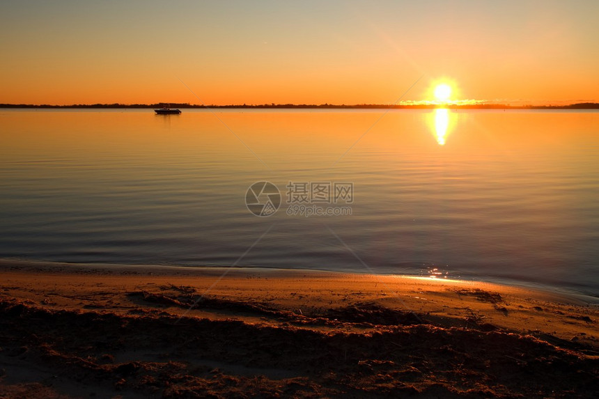 在温暖多彩的日落时平滑的湖泊水图片