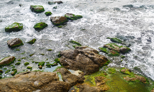 海浪特写镜头有海水的岩石海岸和覆盖着藻类的大岩石与海水图片