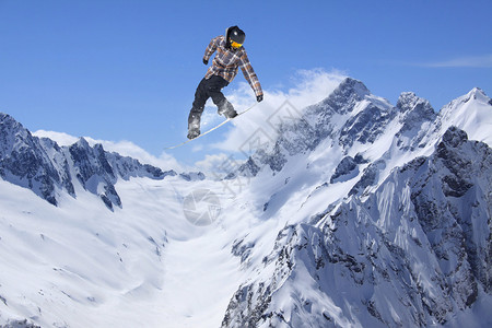 滑雪板在山上跳跃冬季极限运动图片