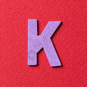 红色背景中的木质纹理紫色字母K图片