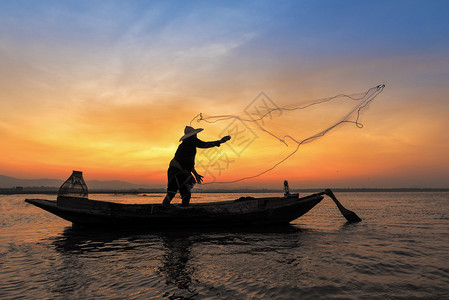 木船在行动扔在自然河在清晨日出前淡水捕鱼网亚洲渔民的剪影背景图片