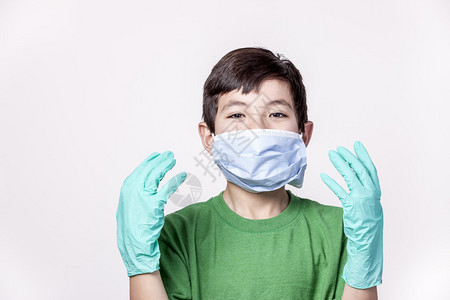 一名年轻男孩戴着医疗面具和橡皮手套图片