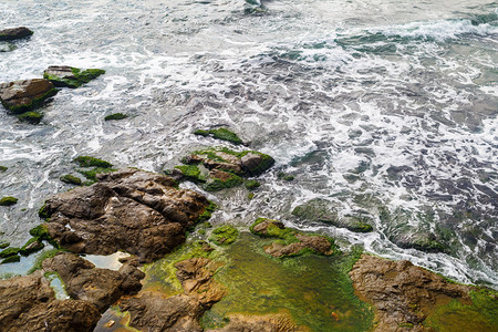 海浪特写镜头海岸有海水和长满藻类的大岩石与海水和巨石图片