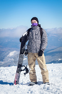 雪山上拿着滑雪板的家伙图片