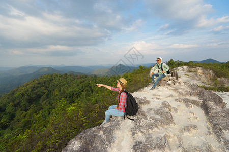 从山顶看山谷景色的年轻背包者旅行概念图片