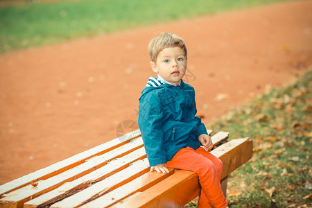 坐在公园长凳上的情绪小男孩图片