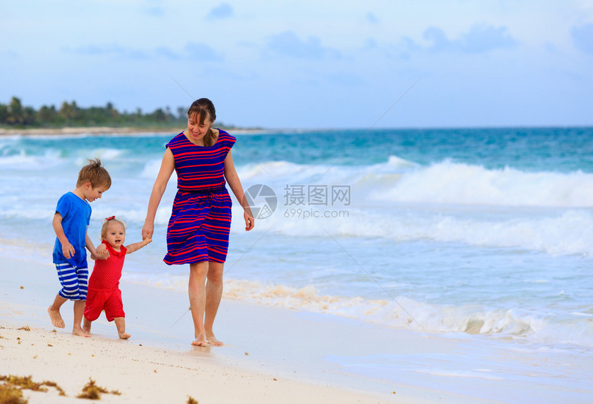 母亲和两个孩子在海滩上散图片