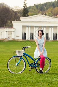 快乐的时装妇女享受弹簧自行车作为业余活动概念的欢快潮图片