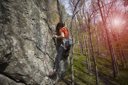 运动员用绳子爬上岩石图片