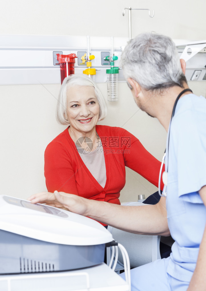快乐的老年女患者在康复中心使用机器图片