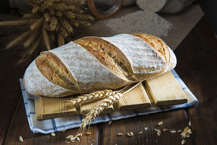 面包房桌上有小麦和面粉的酵母面包图片