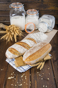 面包房桌上有小麦耳朵和面粉的酵母面包背景图片