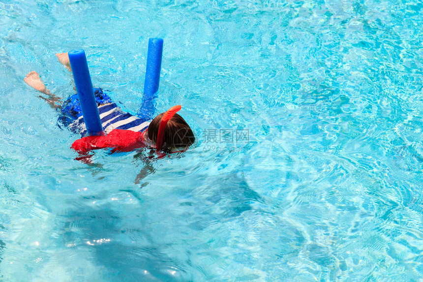 小男孩用游泳池面条和面罩图片
