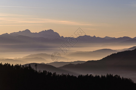 山上美丽的日落山谷中雾笼罩着奥图片