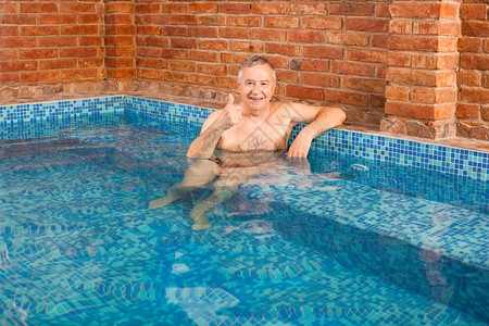 快乐的老人在水力按摩池里放松背景图片