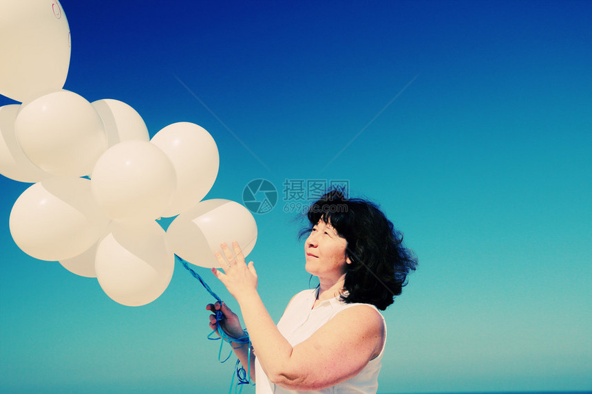 在海边装着白气球图片