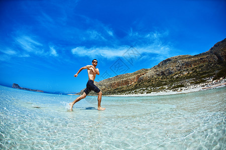 海滨滩上跑来去的健壮的运动男子图片