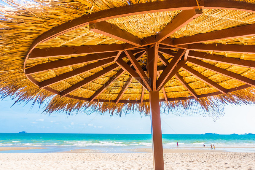 美丽的热带沙滩和蓝天空海边的伞状彩色加亮背景假日概念图片