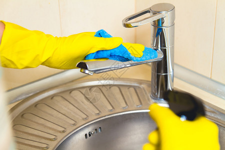 洗水龙头时女用黄色手套清洗厨房图片