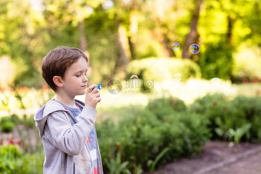 儿童节在公园里吹肥皂泡的小男孩图片