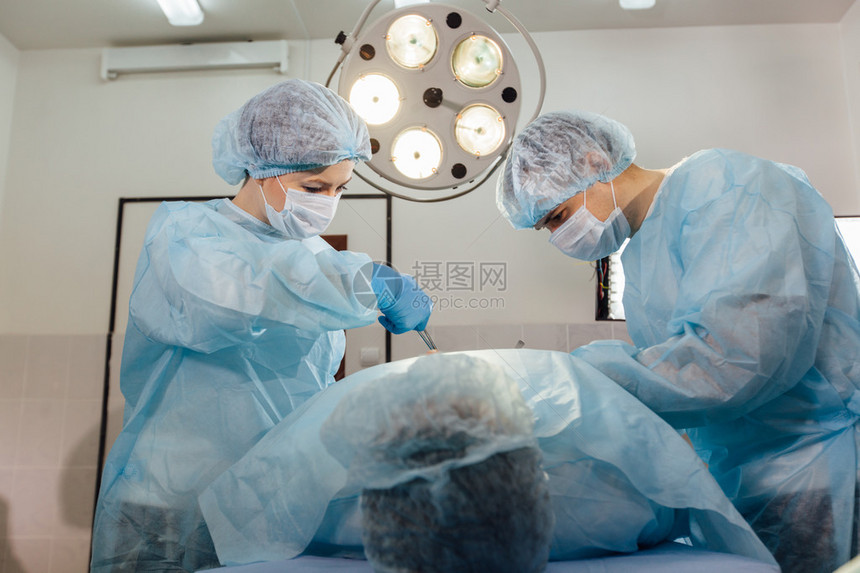 外科医生小组与外科手术室的病人监图片