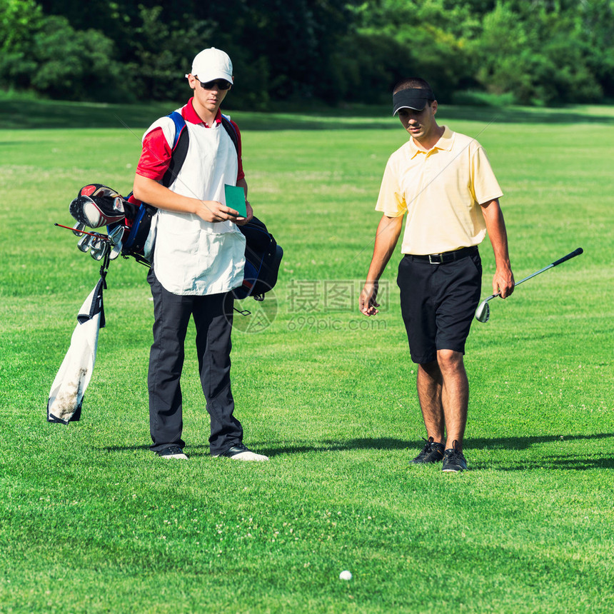 高尔夫球手和球童在高尔夫球场上球躺图片