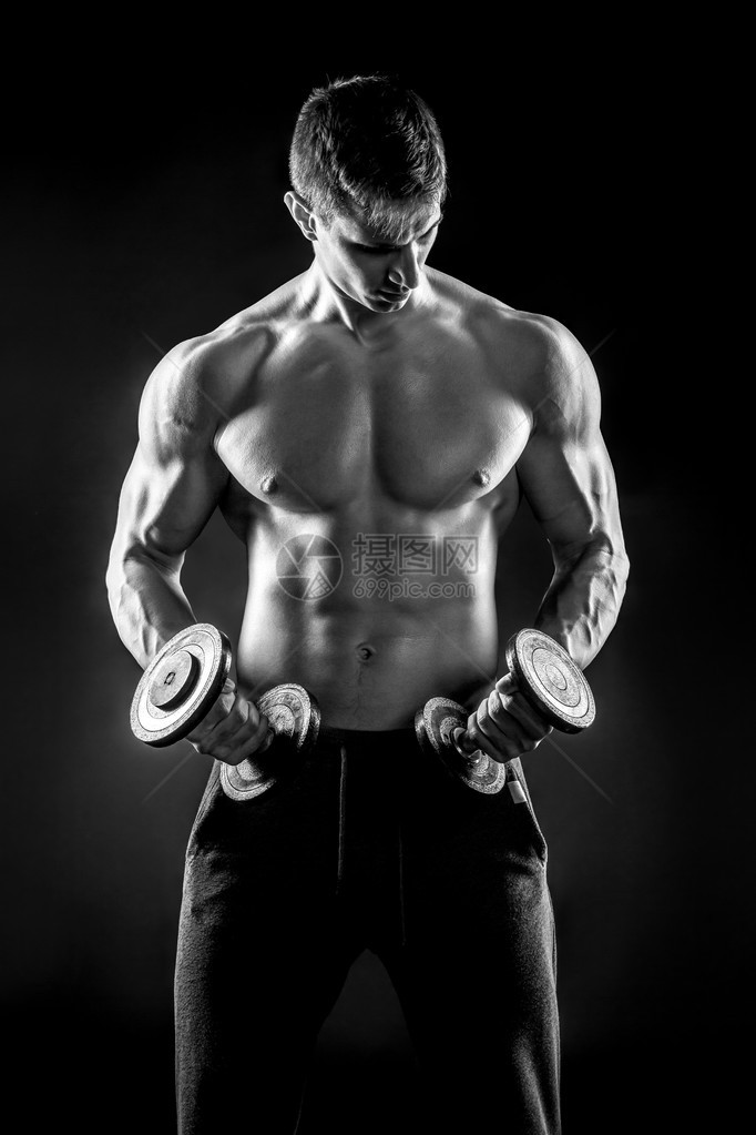 强壮的健身男人在黑色背景上展示他的粗壮身体图片