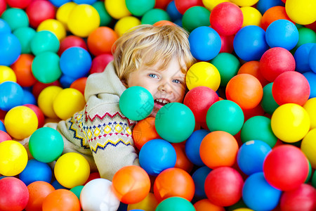 快乐的小男孩在多彩的塑料球游乐场玩耍有趣的孩子在图片