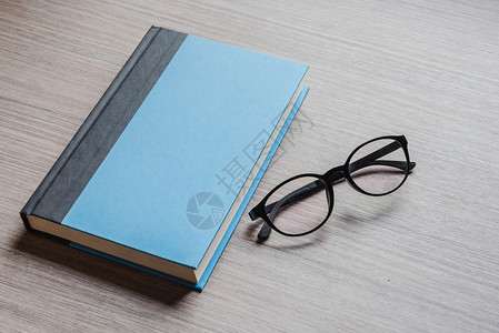 黑色眼镜和蓝笔记本图片