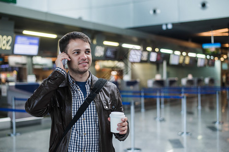 多岁的年轻英俊男子走在现代机场航站楼的肖像图片