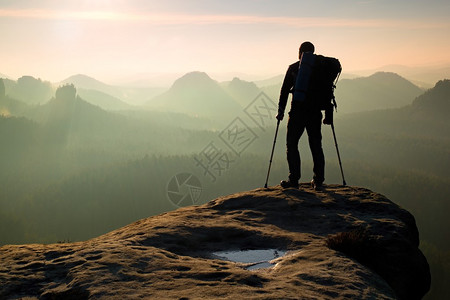 山顶高处的Hiker环绕着药品拐杖图片