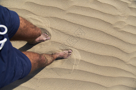 一个人的腿在沙滩上行图片