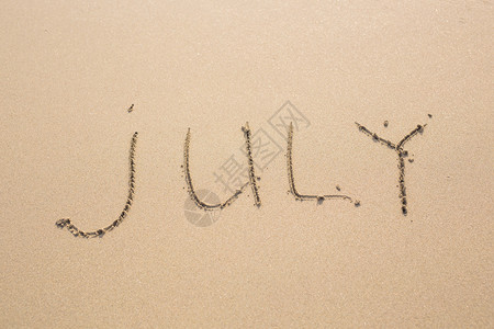 7月在沙滩纹理上用沙子写图片