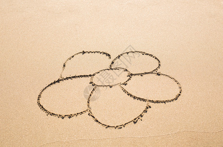 画在沙子里的花在沙滩上的沙子图片